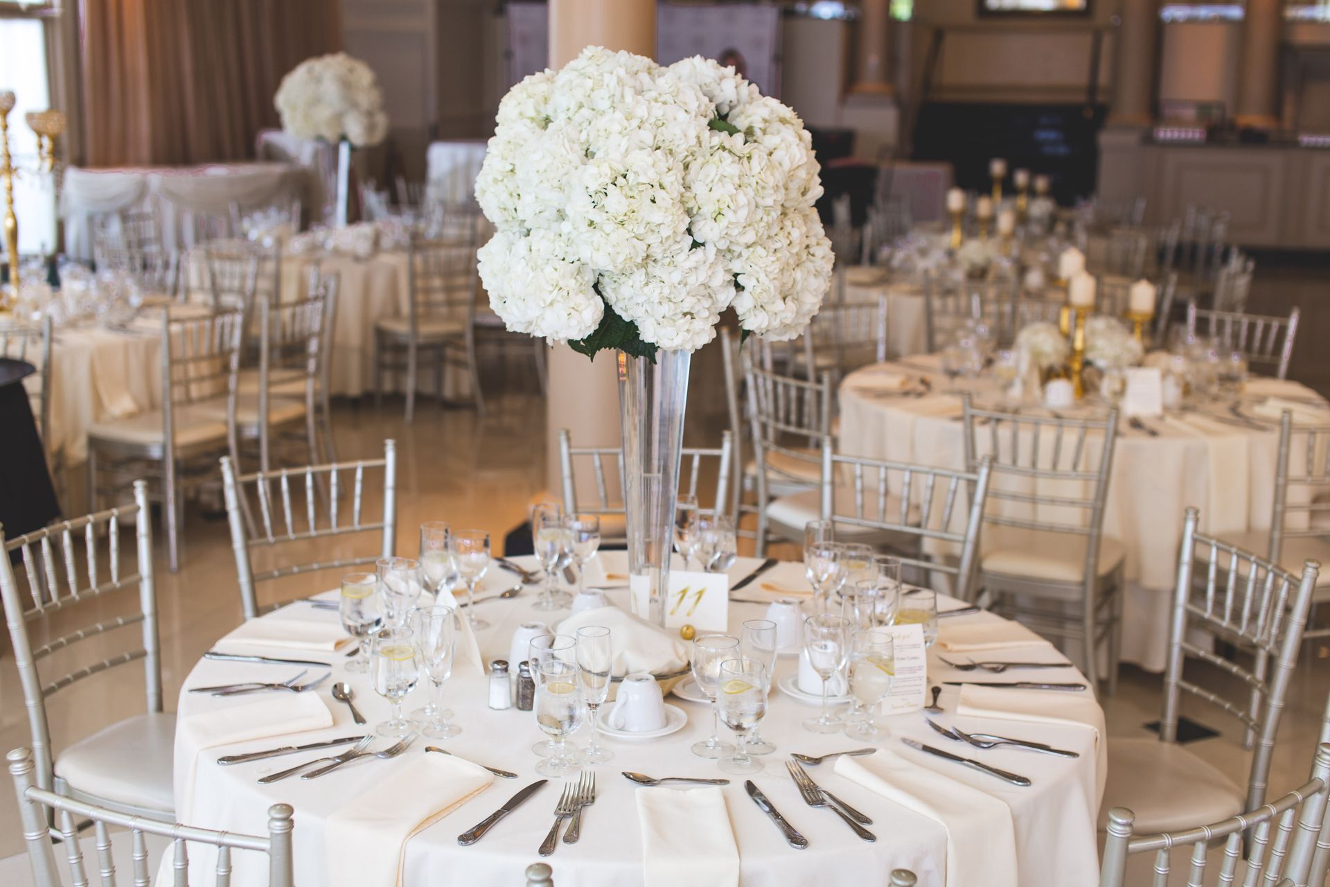 Festlich eingedeckter Gala-Saal mit weißen Blumenarrangements
