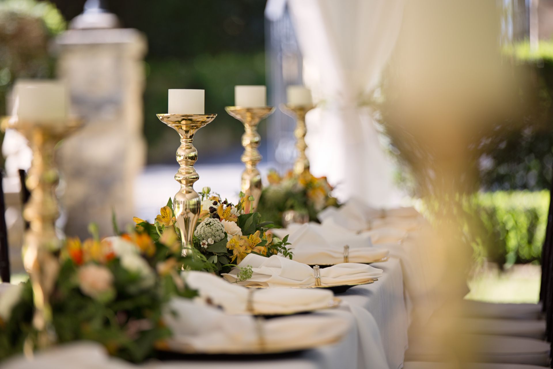 Festliche Hochzeitstafel im Freien mit goldenen Kerzenleuchtern