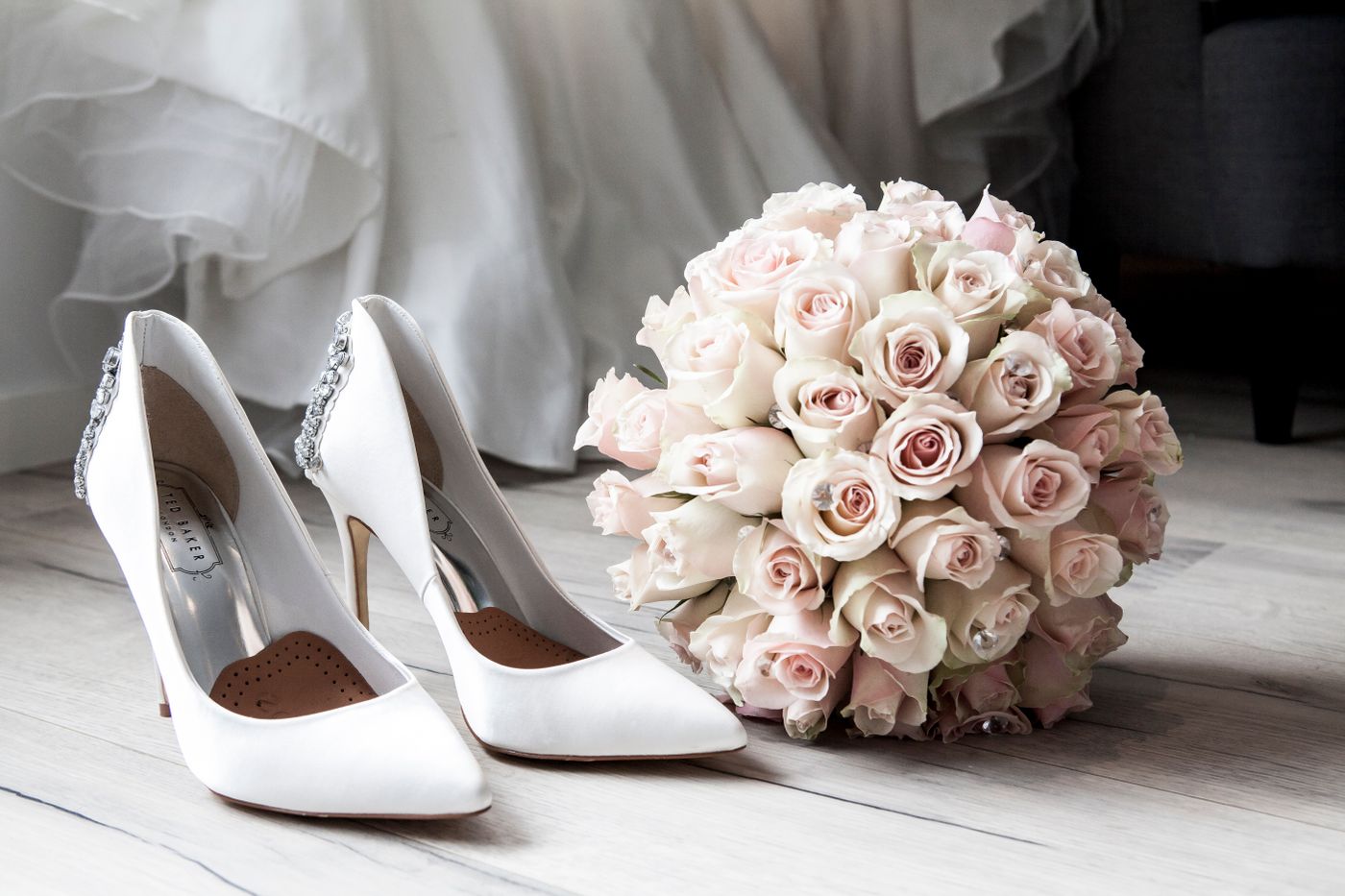 Brautstrauß in zarten Pudertönen neben eleganten Brautschuhen